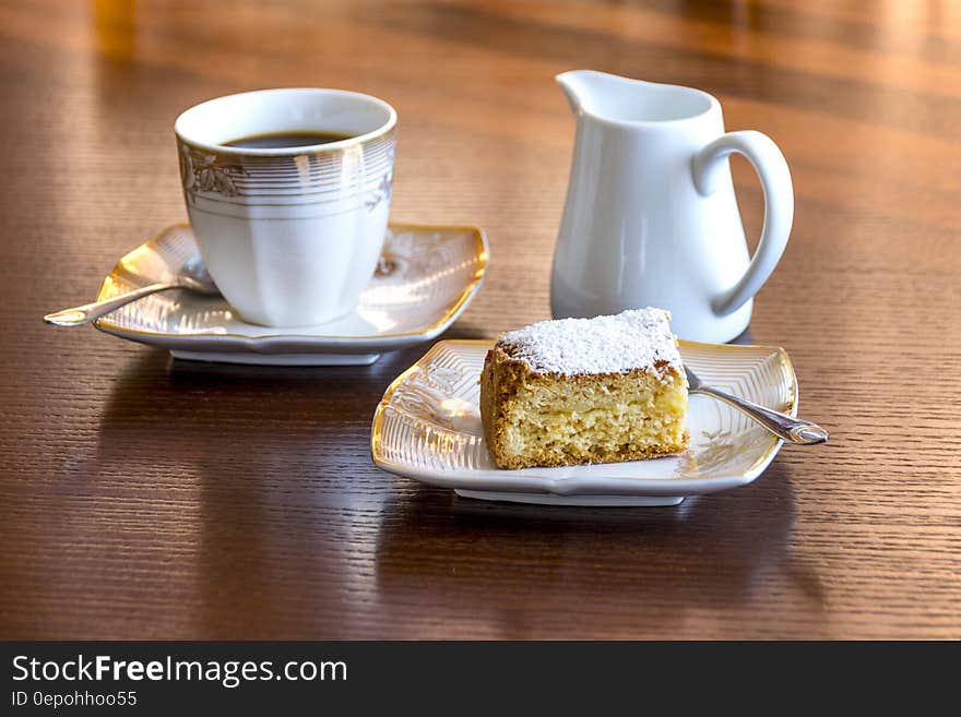 White Ceramic Mug Filled With Black Liquid Beside Baked Bread on Ceramic Saucer