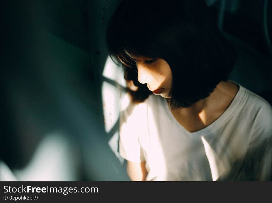 Woman Wearing White V Neck T Shirt Leaning on White Wall