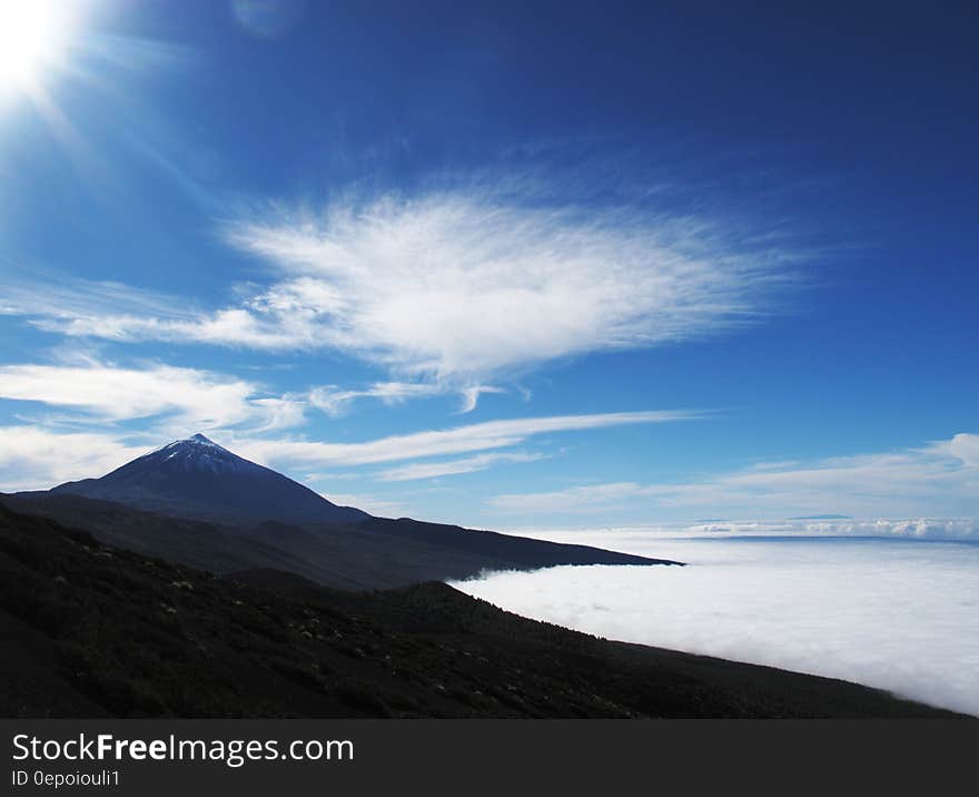 Brown Concrete Mountain Under Blue and White Sky during Dayitme