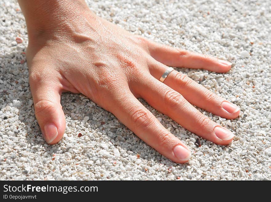 Lef Humand Hand Wearing Silver Ring on the Soil