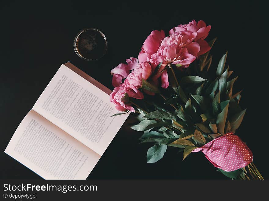 Pink Flower Bouquet Beside Opened Book