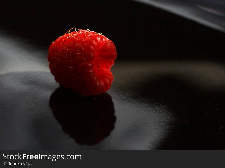 Closeup of red fresh raspberry fruit on a dark surface with reflection. Closeup of red fresh raspberry fruit on a dark surface with reflection.