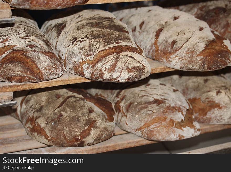 Loaves of bread on racks in a bakery.