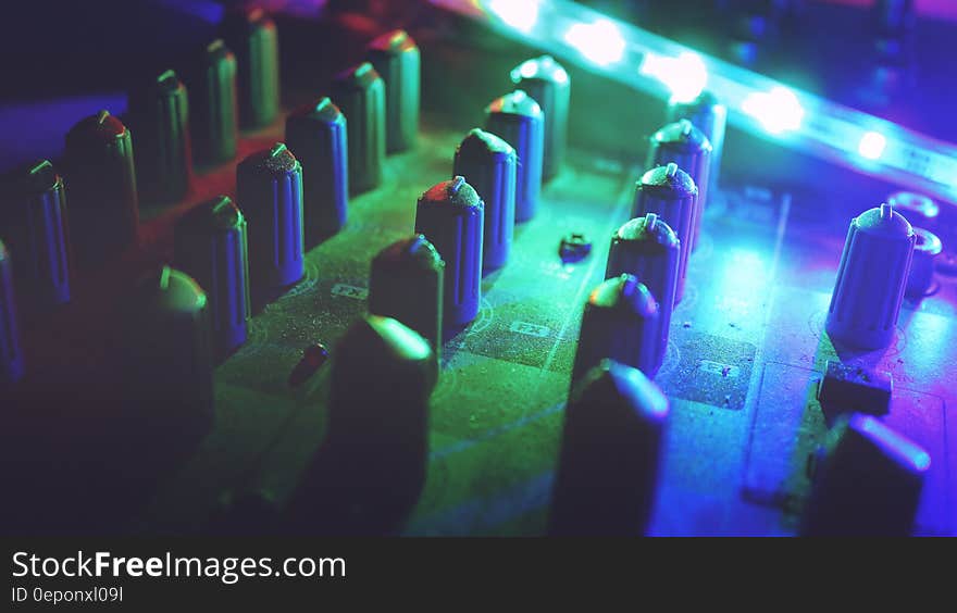 A mixing table under colorful led lights.