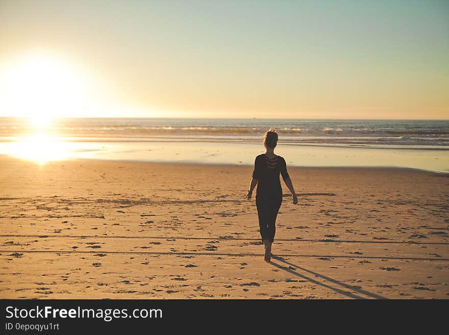 A girl on the beach with sun low in the horizon. A girl on the beach with sun low in the horizon.