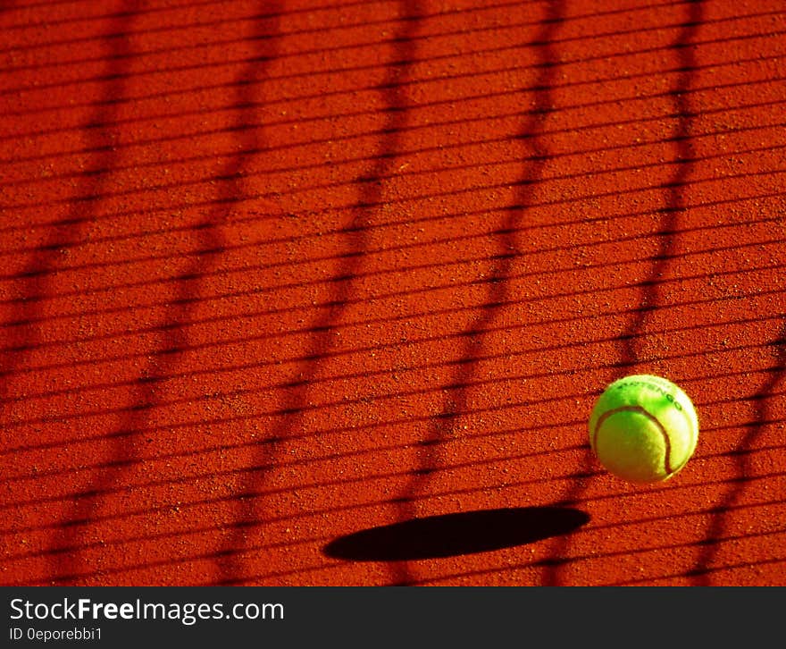 Green Tennis Ball on Red Floor during Sunny Day