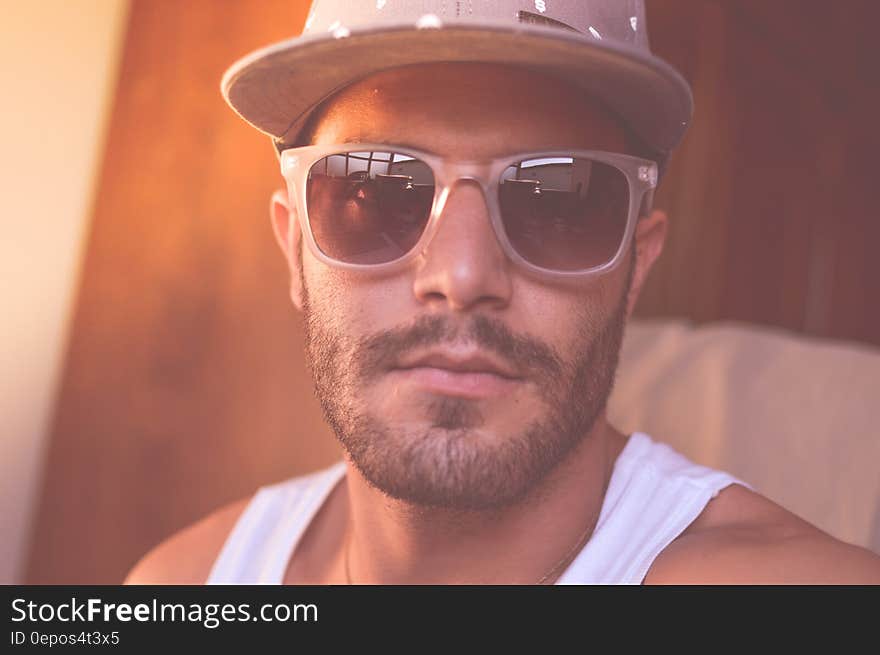 Closeup portrait of man in hard hat and white vest with beard and moustache and dark glasses, possibly African American construction worker. Closeup portrait of man in hard hat and white vest with beard and moustache and dark glasses, possibly African American construction worker.