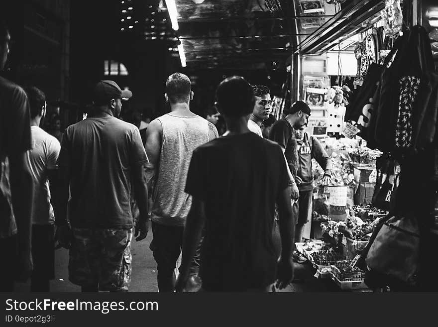 Group of men walking down urban street at night in black and white. Group of men walking down urban street at night in black and white.