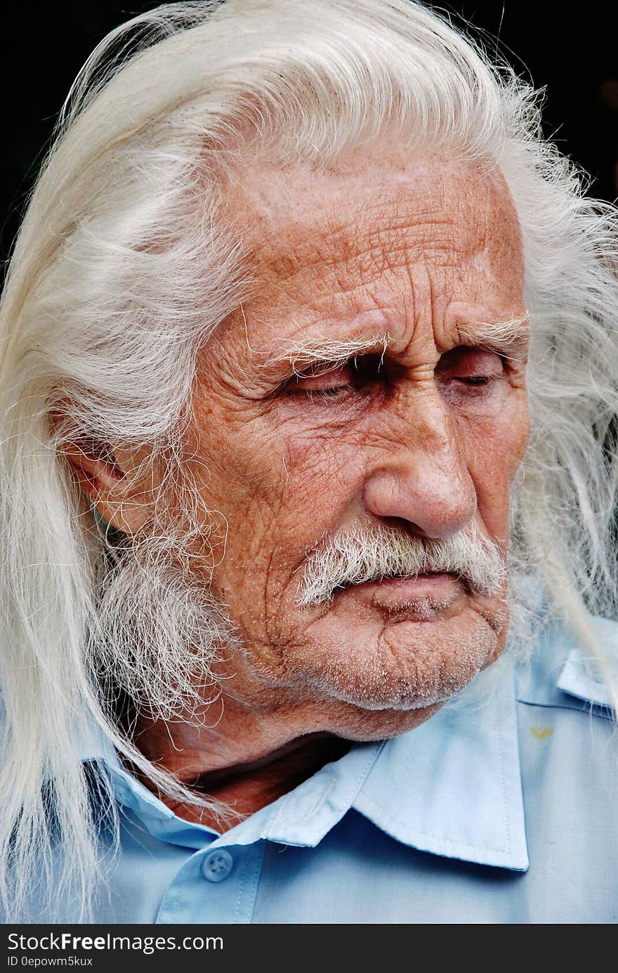 Portrait of senior man with long grey hair and mustache.