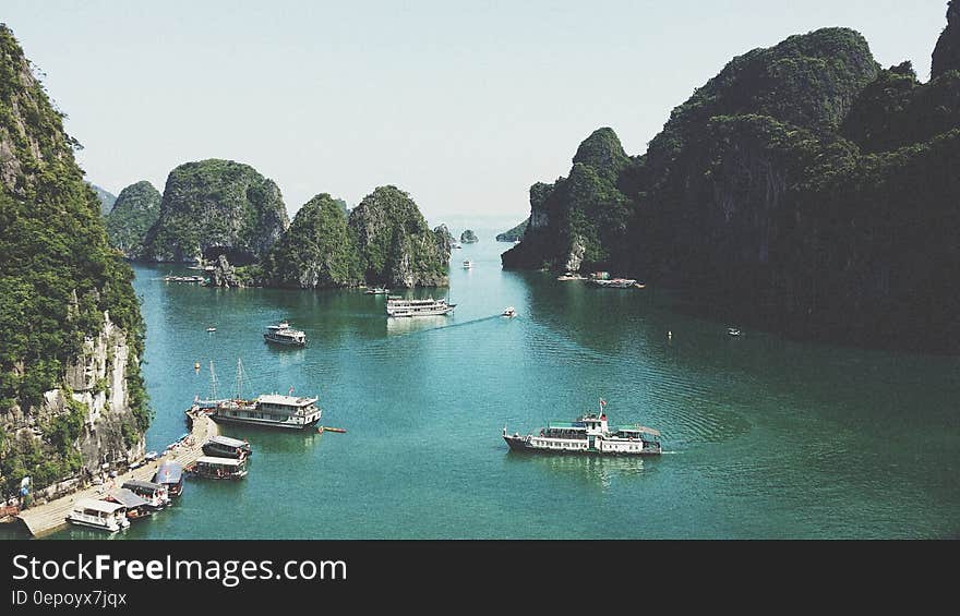 Boats in harbor at dock in blue waters of Halong, Vietnam on sunny day. Boats in harbor at dock in blue waters of Halong, Vietnam on sunny day.