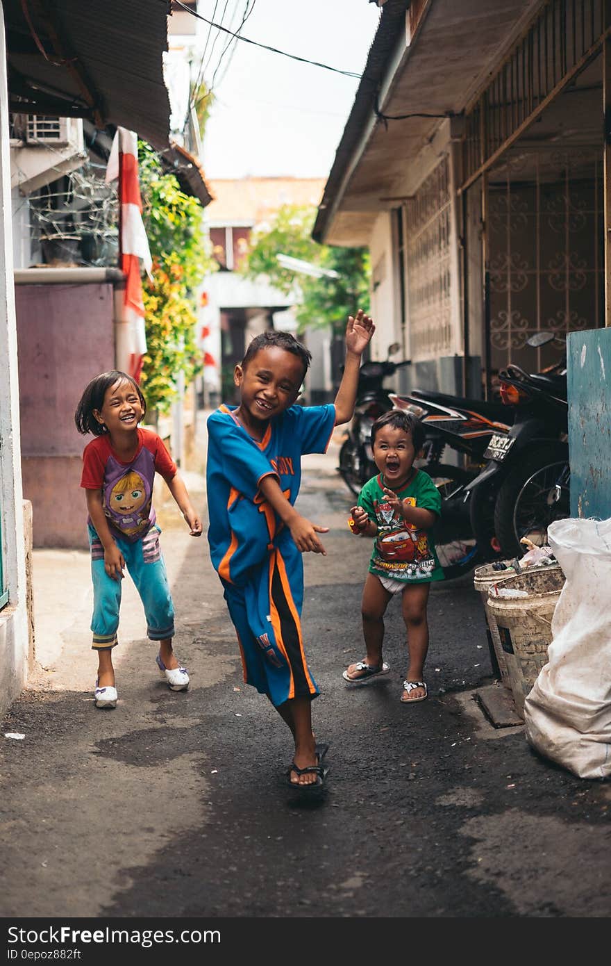 Child in Blue and Yellow Jersey Shirt With the Two Other Kids