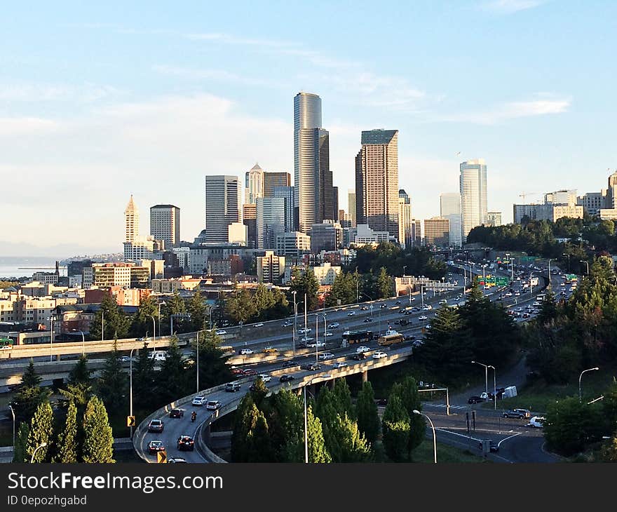 Traffic on highway leading out of urban city with skyline against blue skies. Traffic on highway leading out of urban city with skyline against blue skies.