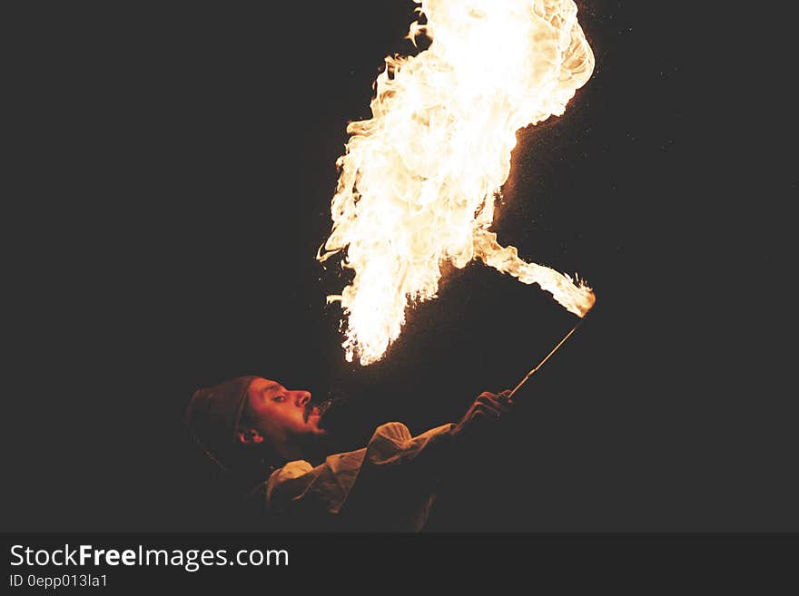 Man Blowing Fire during Nighttime