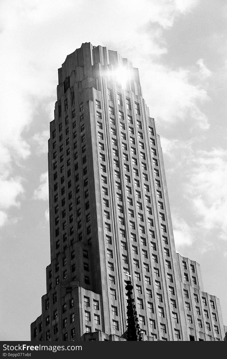 Sun reflecting off front of modern skyscraper in black and white.