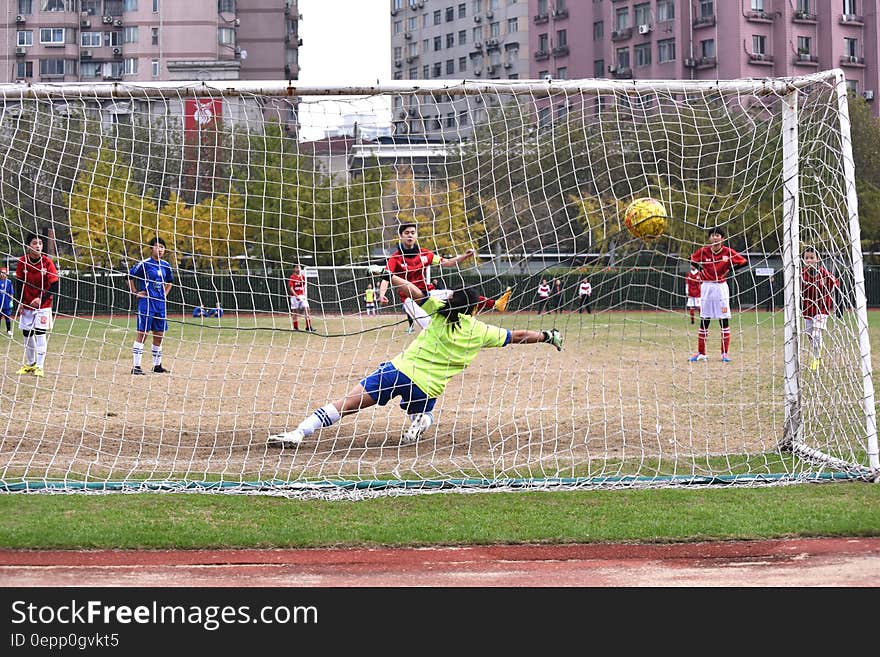 Goalie in net at outdoor youth soccer or football match. Goalie in net at outdoor youth soccer or football match.