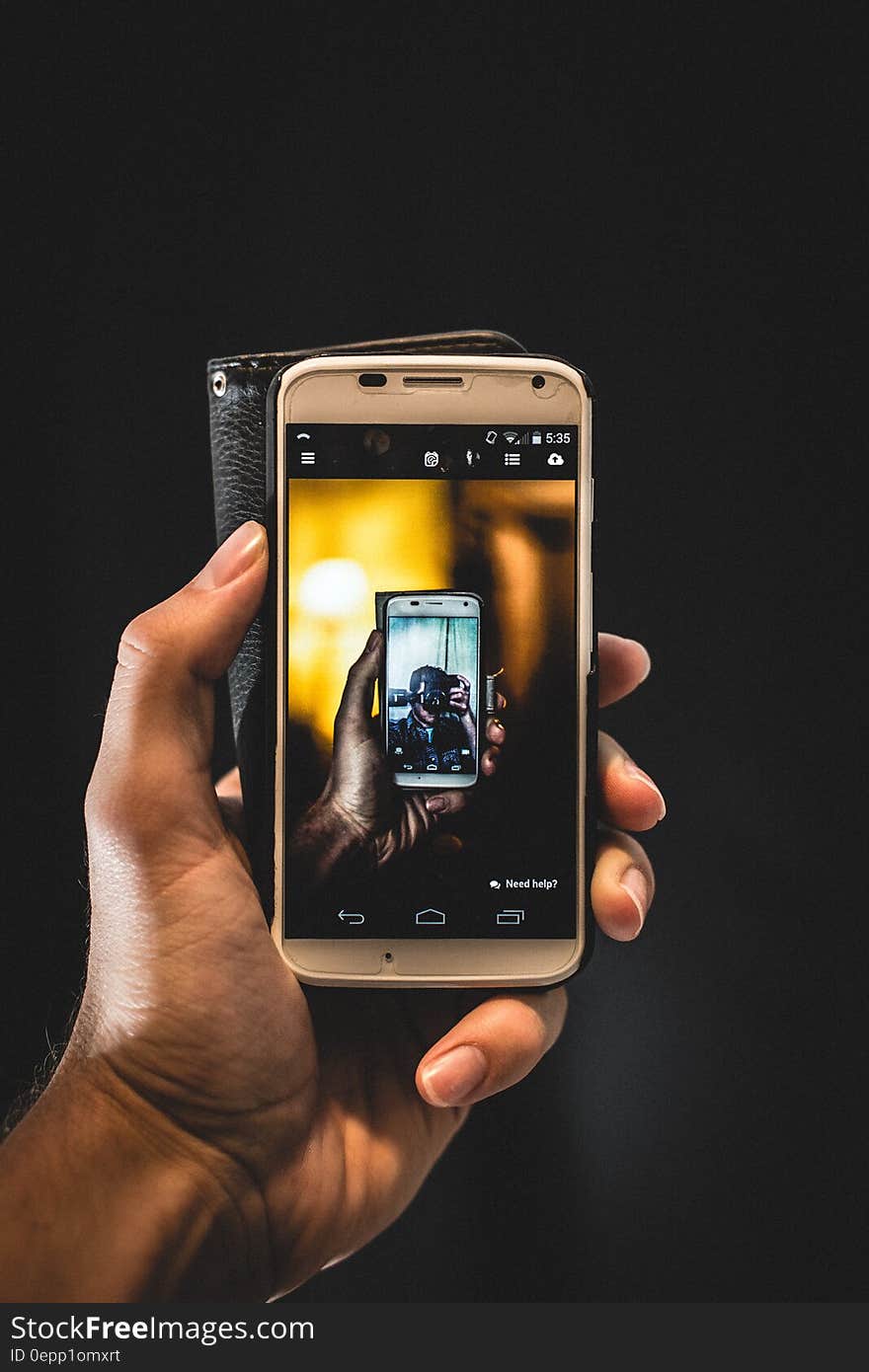 Close up of hand holding smartphone with image on touchscreen.