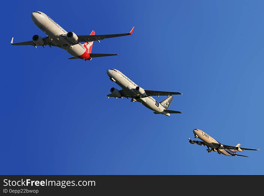 Commercial airplanes flying in formation in blue skies. Commercial airplanes flying in formation in blue skies.