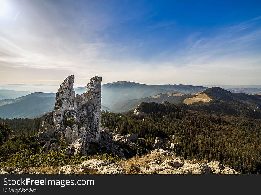 Photo of Green Trees Near Grey Rack Mountain Under Blue Sky during Daytime