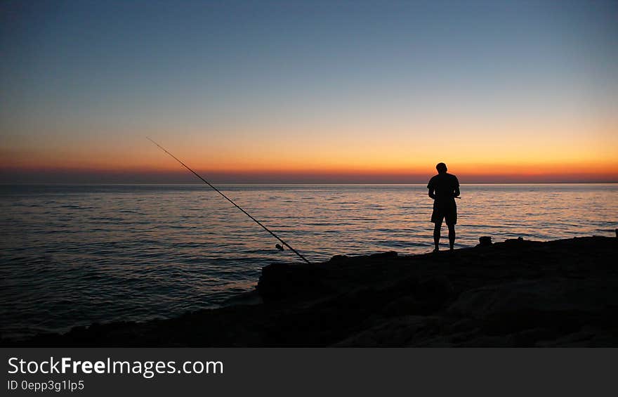 Person Fishing during Sunset