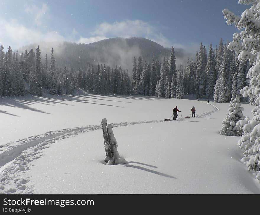 2 Person Walking on Snowfield during Daytime