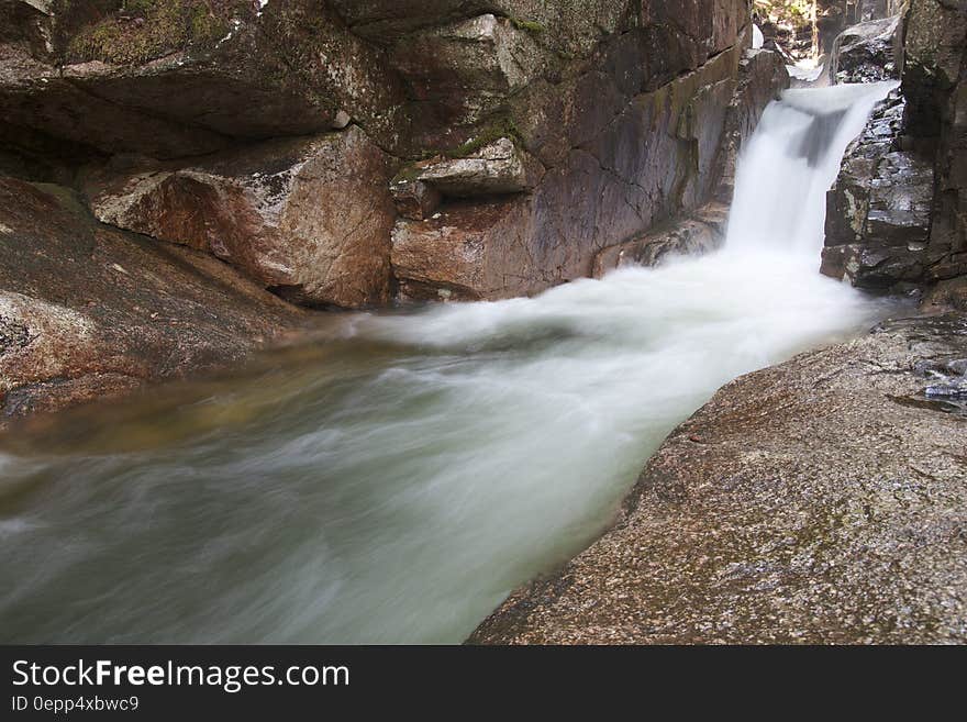 Blur of water over falls along rocky shores in stream. Blur of water over falls along rocky shores in stream.