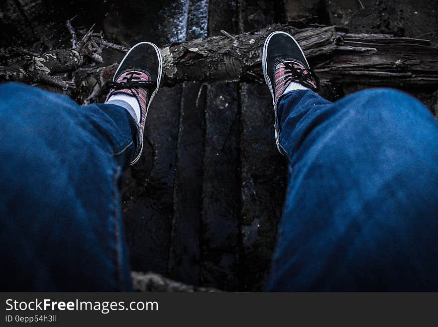 Person Wearing Blue Denim Jeans Above Black Surface