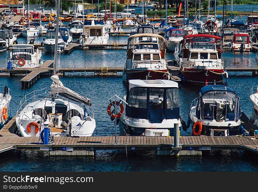 White Blue Sailboats Dock on Water during Daytime