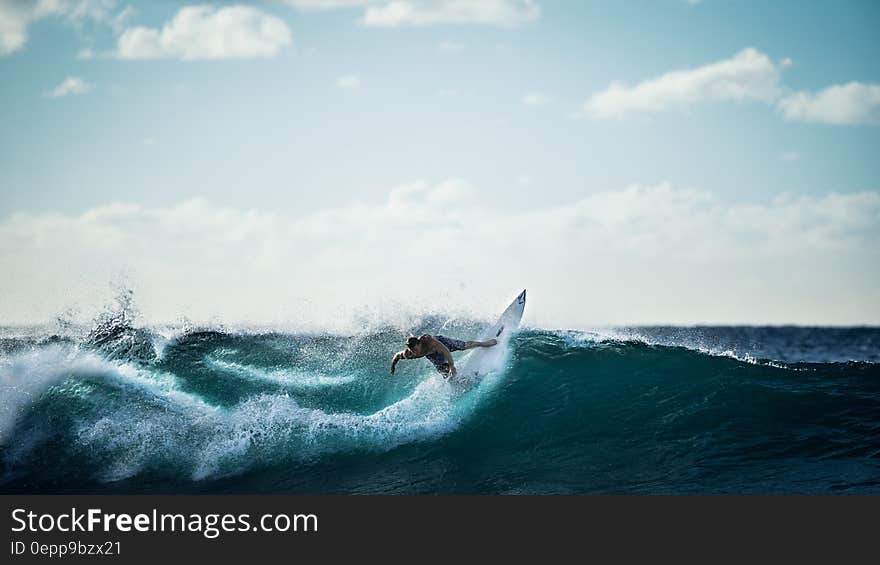 Surfer catching and riding ocean wave on sunny day. Surfer catching and riding ocean wave on sunny day.