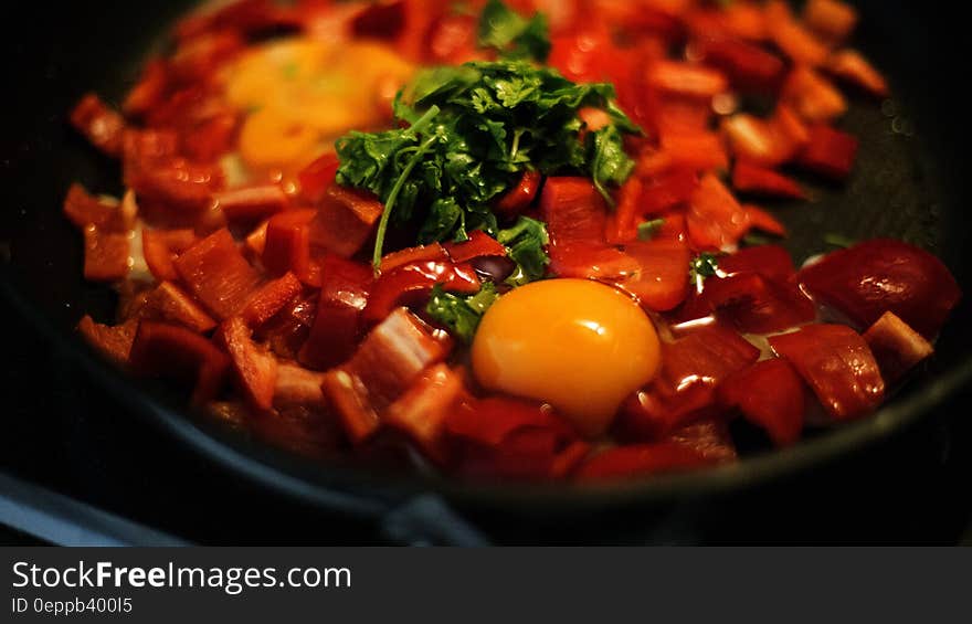 Close up of pan with bell peppers and raw egg. Close up of pan with bell peppers and raw egg.