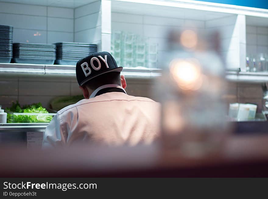 Man in White Button Up Shirt Wearing Boy Printed Black and White Fitted Hat