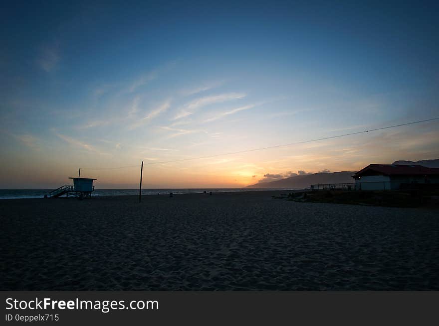 Seashore Under Blue Sky With Brown Clouds during Sunrise