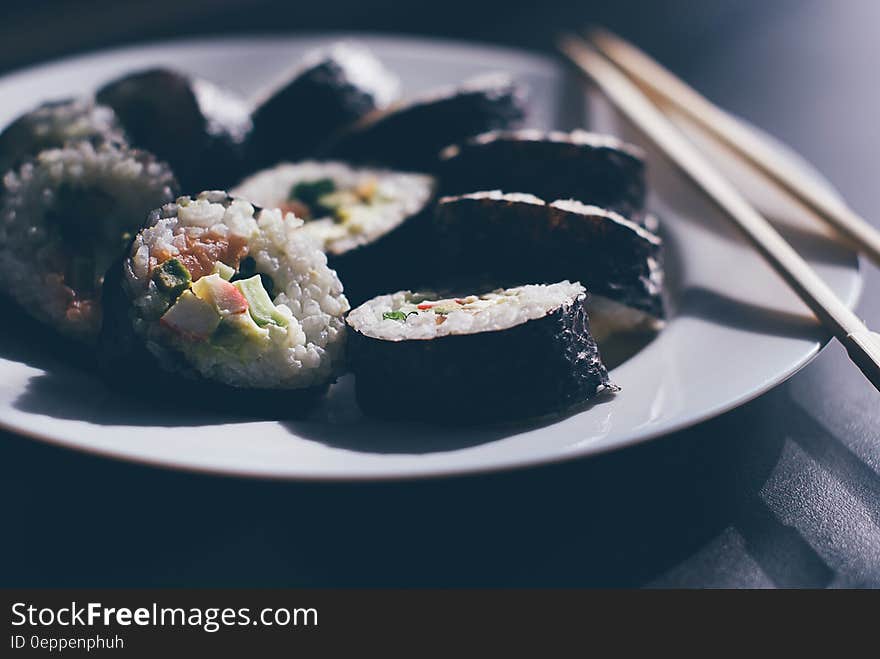 Close up of plate of sushi rolls with chopsticks. Close up of plate of sushi rolls with chopsticks.