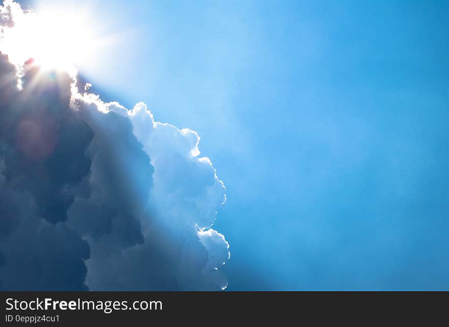 The blue skies with a sun peeking from behind a cloud. The blue skies with a sun peeking from behind a cloud.