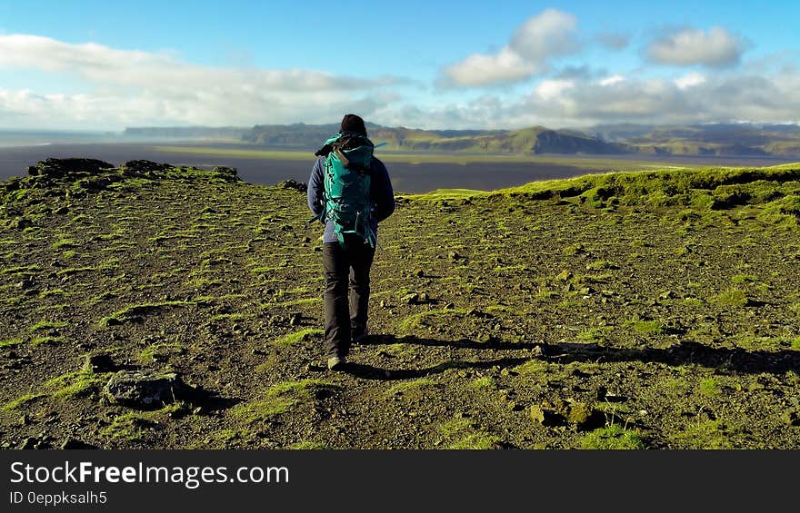 Person in Green Coat Walking on Mountain