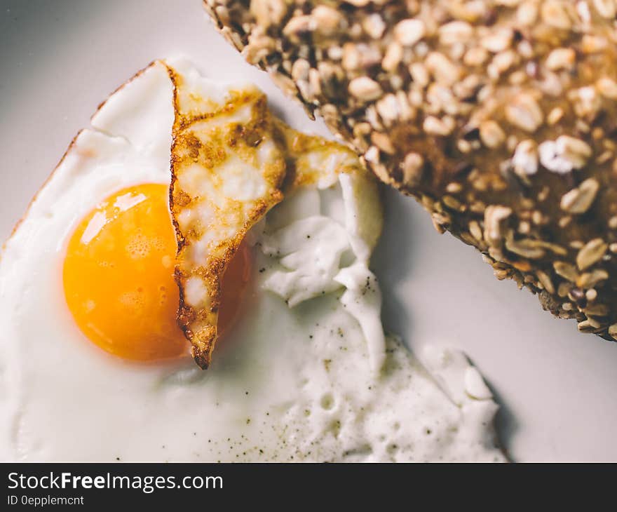 A close up shot of a fried egg and integral bread beside.