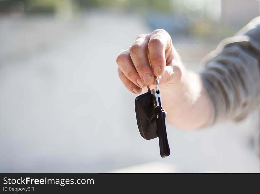 Person in Grey Shirt Handing Keys