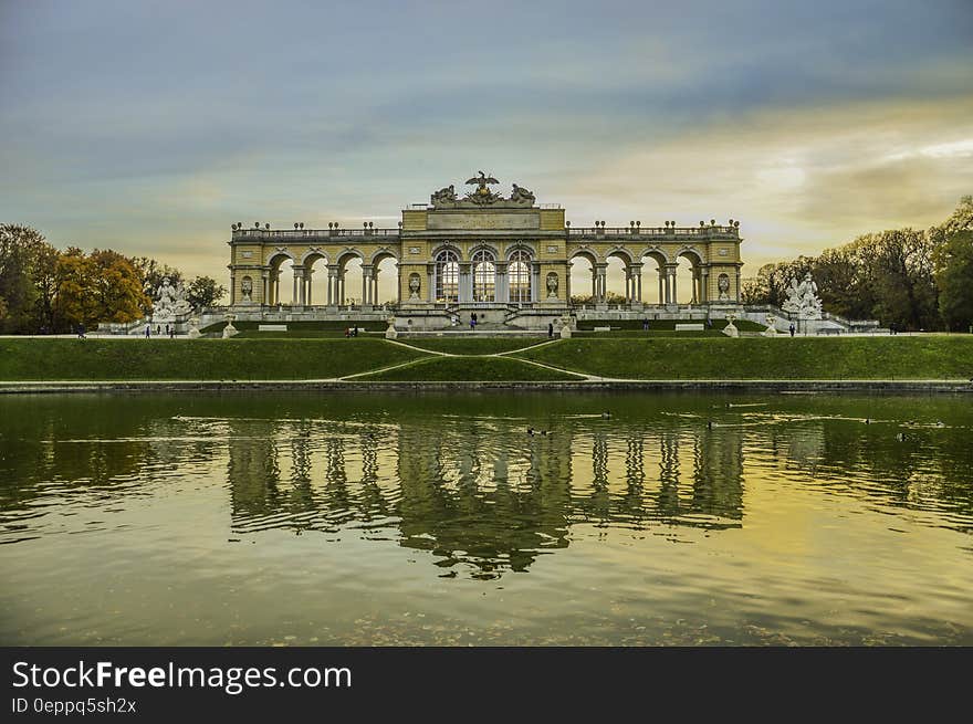 Reflection of gateway in pond at Schonbrunn Palace Gardens, Vienna, Austria at sunset.