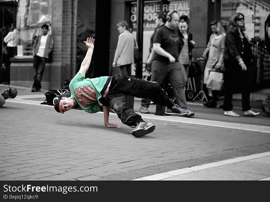 Break dancer performing on city streets with surroundings in black and white. Break dancer performing on city streets with surroundings in black and white.