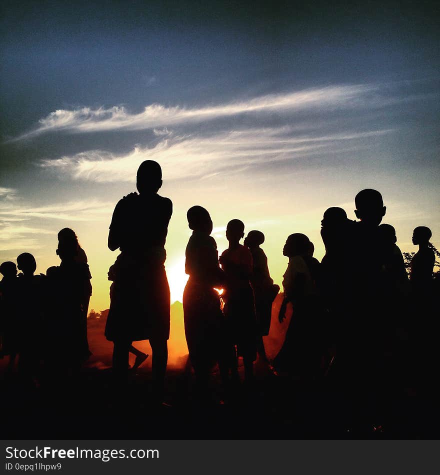 Silhouette of people standing outdoors at sunset. Silhouette of people standing outdoors at sunset.