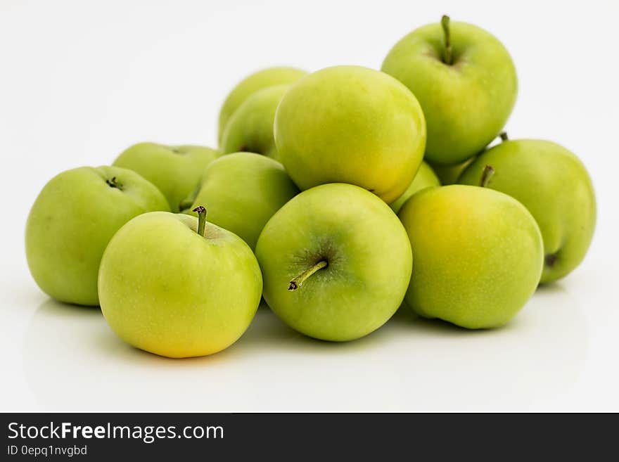 Pile of green apples on white.