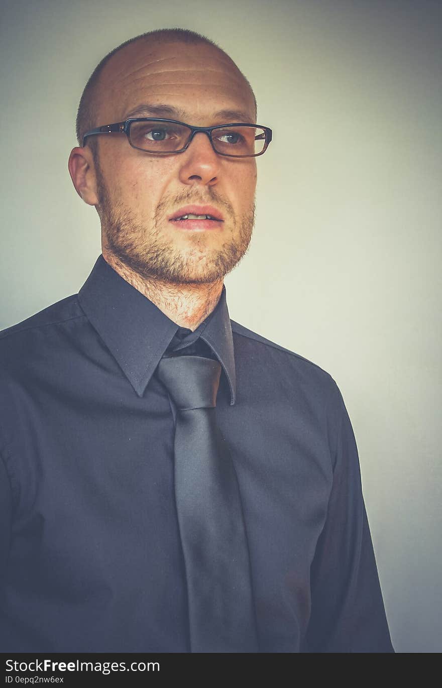 Studio portrait of man in blue shirt and tie wearing eyeglasses. Studio portrait of man in blue shirt and tie wearing eyeglasses.