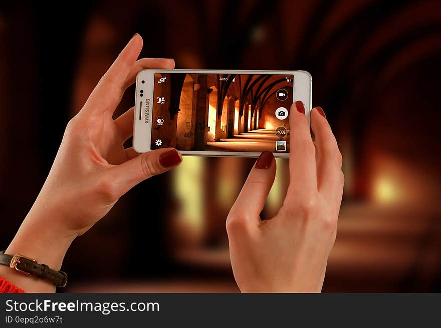 Woman Holding a White Samsung Galaxy Android Smartphone Taking a Photo of Hallway