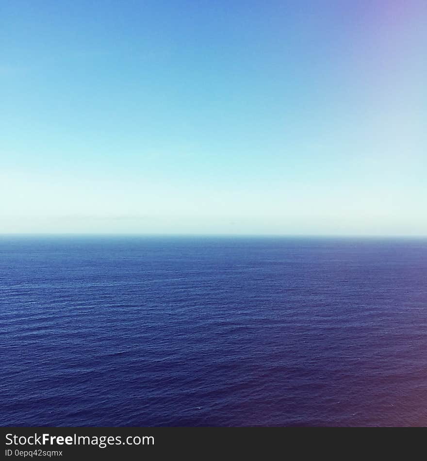 Blue ocean and skies above it.