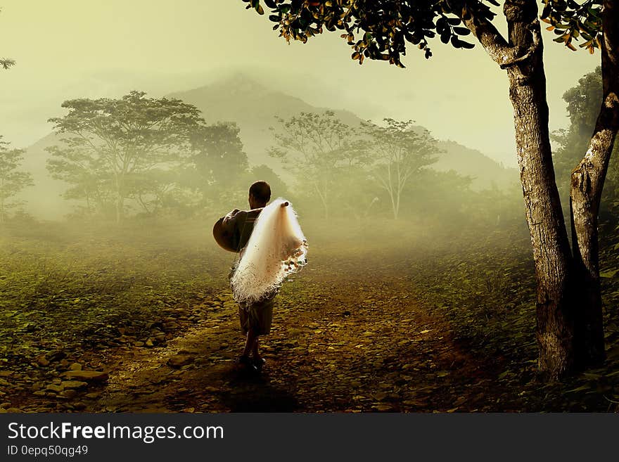 Man in Brown Robe Carrying White Fishing Net