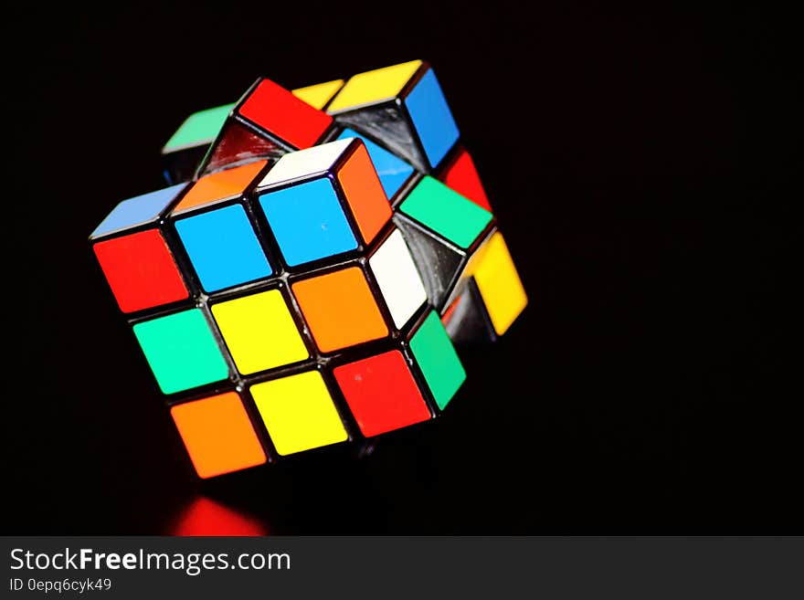 Mixed up Rubik's cube reflecting on black background with copy space. Mixed up Rubik's cube reflecting on black background with copy space.