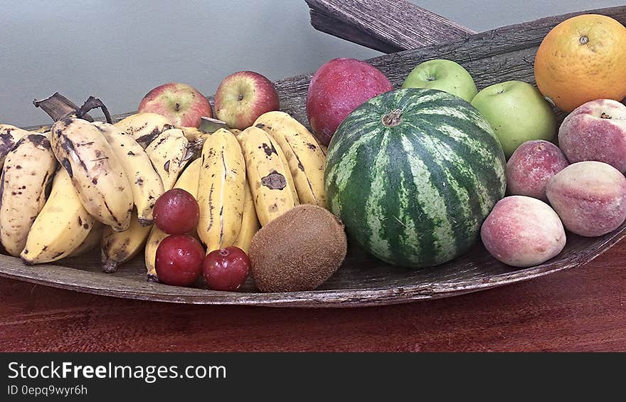 Whole fresh fruit on wooden platter.