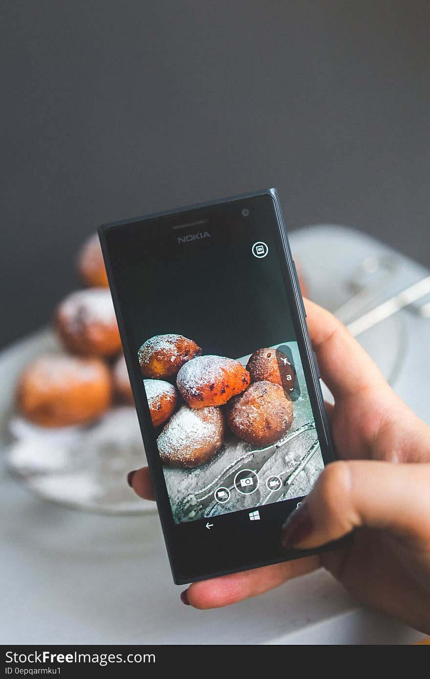 Woman hand taking picture of doughnuts