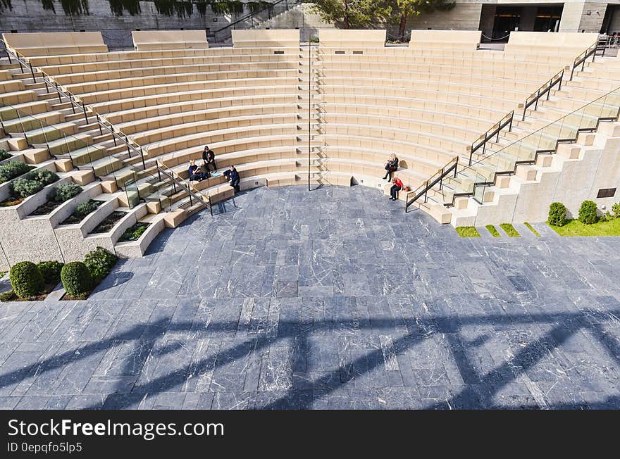 People sitting in large outdoor amphitheater on sunny day. People sitting in large outdoor amphitheater on sunny day.