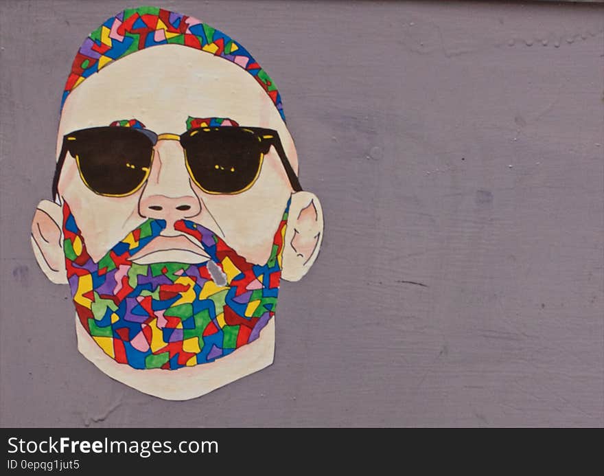 Graffiti art of man with colorful hair and beard wearing sunglasses on wall. Graffiti art of man with colorful hair and beard wearing sunglasses on wall.