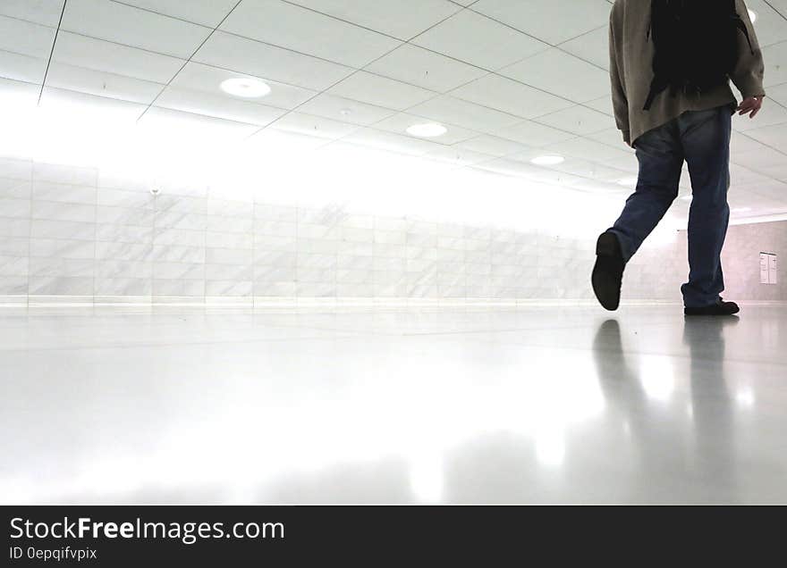 Man walking down white corridor in modern architecture. Man walking down white corridor in modern architecture.